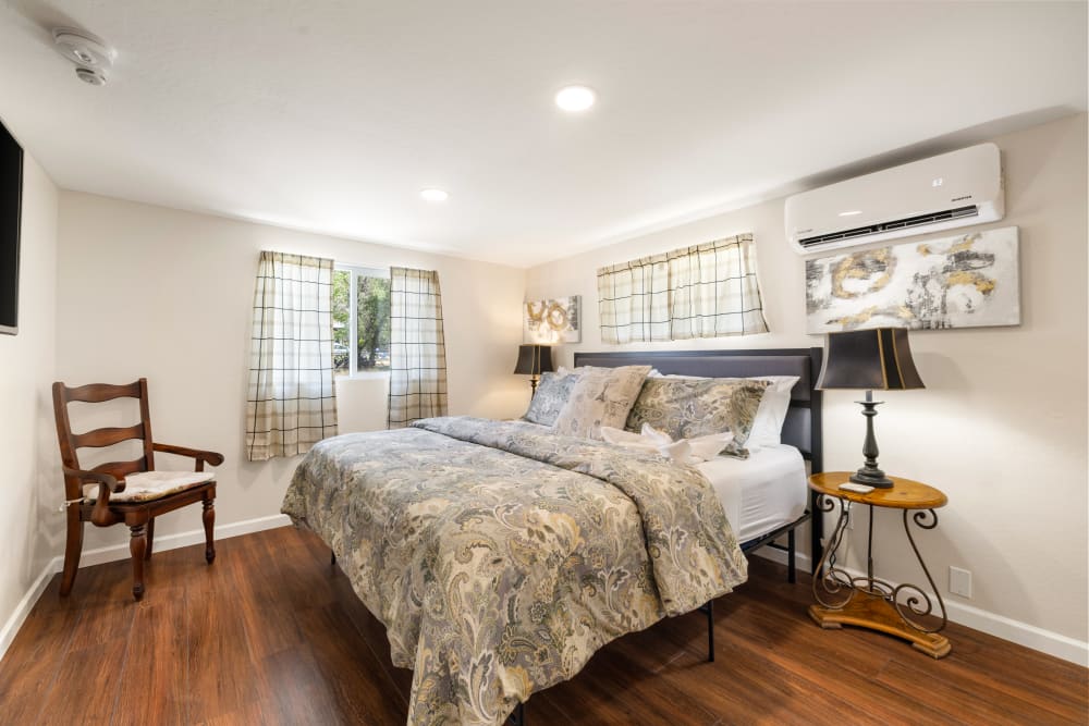 The master bedroom is a serene retreat featuring a luxurious king-sized bed with plush pillows and a soft, inviting duvet. Opposite the bed, a 43