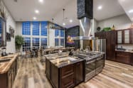 Great room / Kitchen centrally located in the home. 60” stovetop with 8 gas burners, 2 griddles, seating for up to 20 people, 86” Smart TV, 17’ floor to ceiling windows with incredible views of the Prescott Mountains.