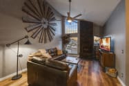 East-wing Livingroom, 2 leather sofas, wood fireplace set in floor to ceiling stone, 55