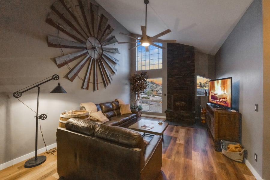 East-wing Livingroom, 2 leather sofas, wood fireplace set in floor to ceiling stone, 55