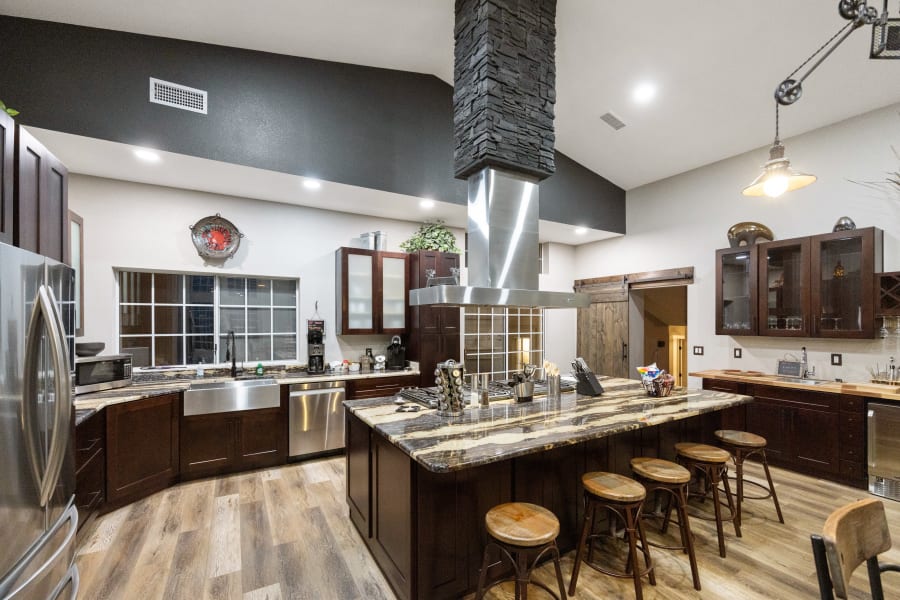 Seating area at custom granite counter surrounding 60” stove. Stoneware dishes and utensils for up to 24 guests, pots & pans for cooking large meals, roaster oven, crockpot, both Keurig & drip coffee makers, grinder, bread maker, etc Just gorgeous!
