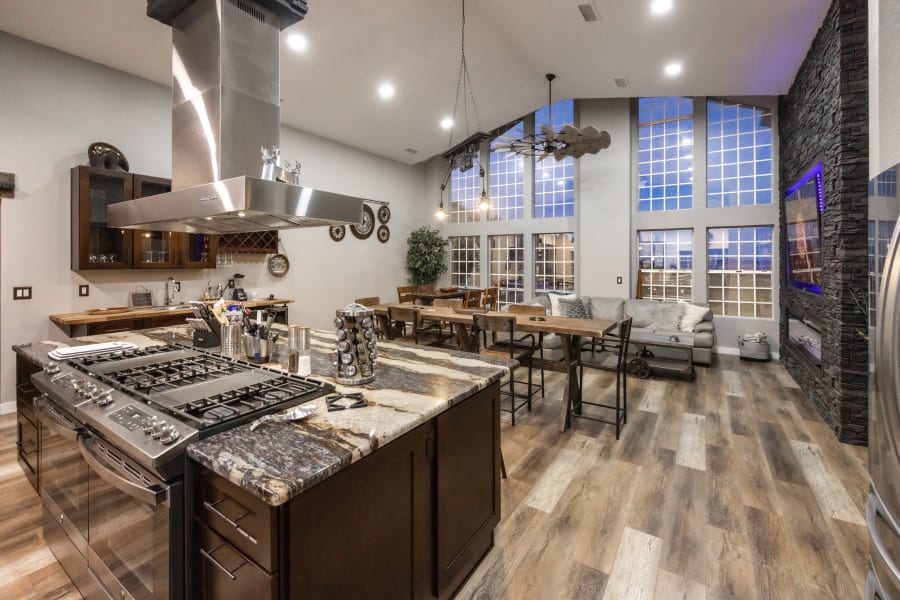 Great room / Kitchen centrally located in the home. 60” stovetop with 8 gas burners, 2 griddles, seating for up to 20 people, 86” Smart TV, 17’ floor to ceiling windows with incredible views.