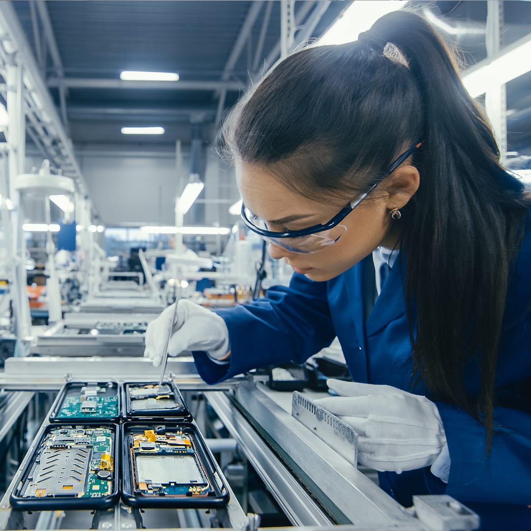 Frau bestückt Platinen auf Smartphone