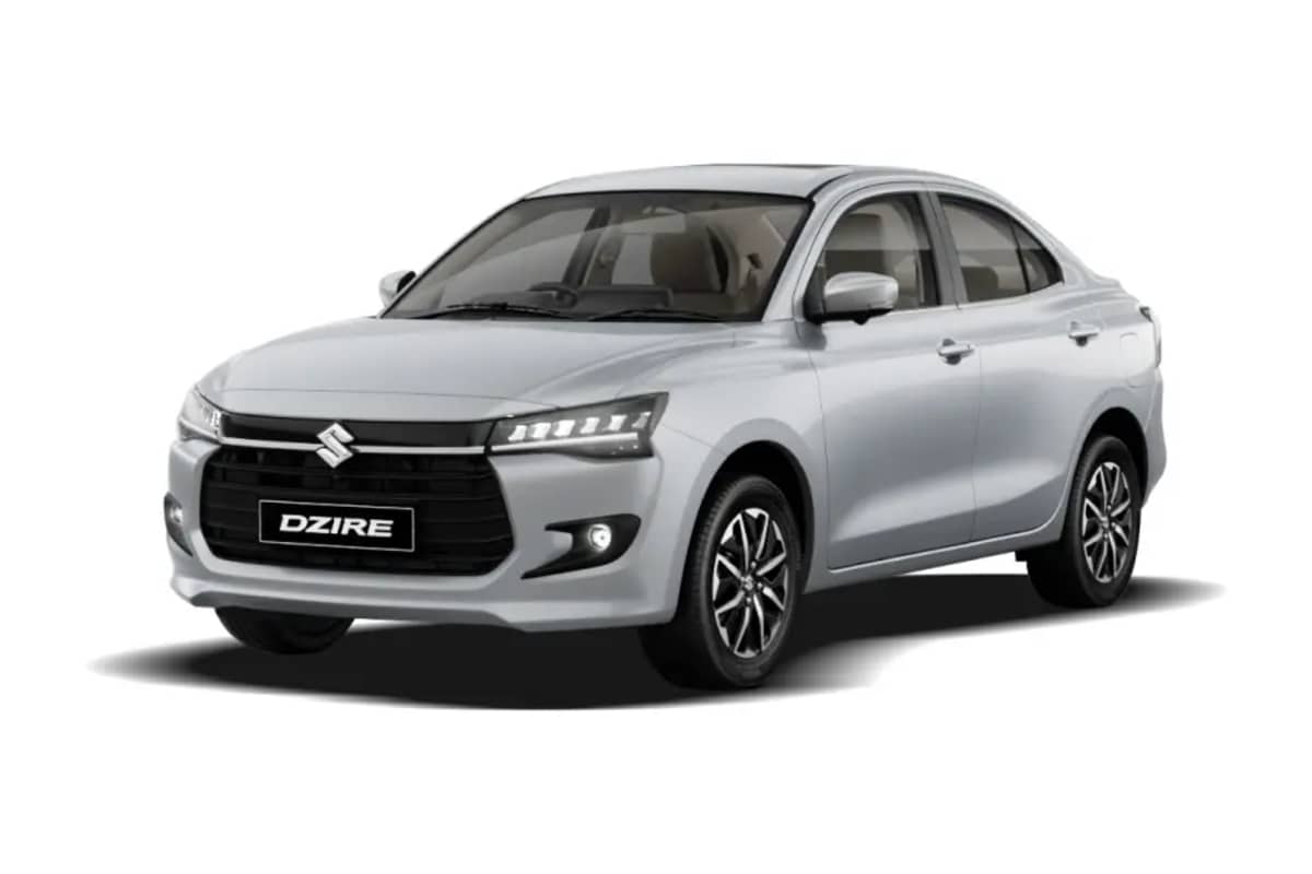 Maruti Suzuki Dzire compact sedan showcasing multi-slat black grille, LED headlights, and aerodynamic styling.