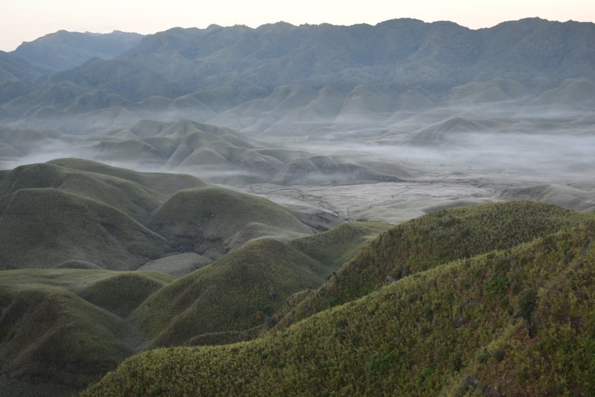 Panoramic vista across the undulating high-altitude meadows and rolling mountain ridges along the Nagaland border