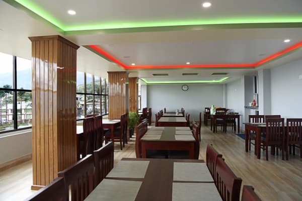 Restaurant interior featuring timber clad pillars and ambient cove ceiling lighting.