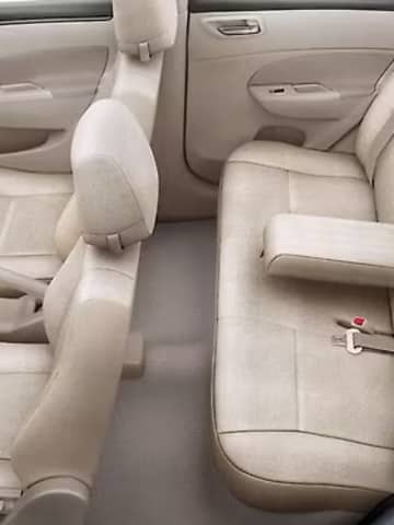 Maruti Suzuki Dzire passenger cabin featuring plush beige fabric seats, rear central armrest with cup holders, and ergonomic legroom.