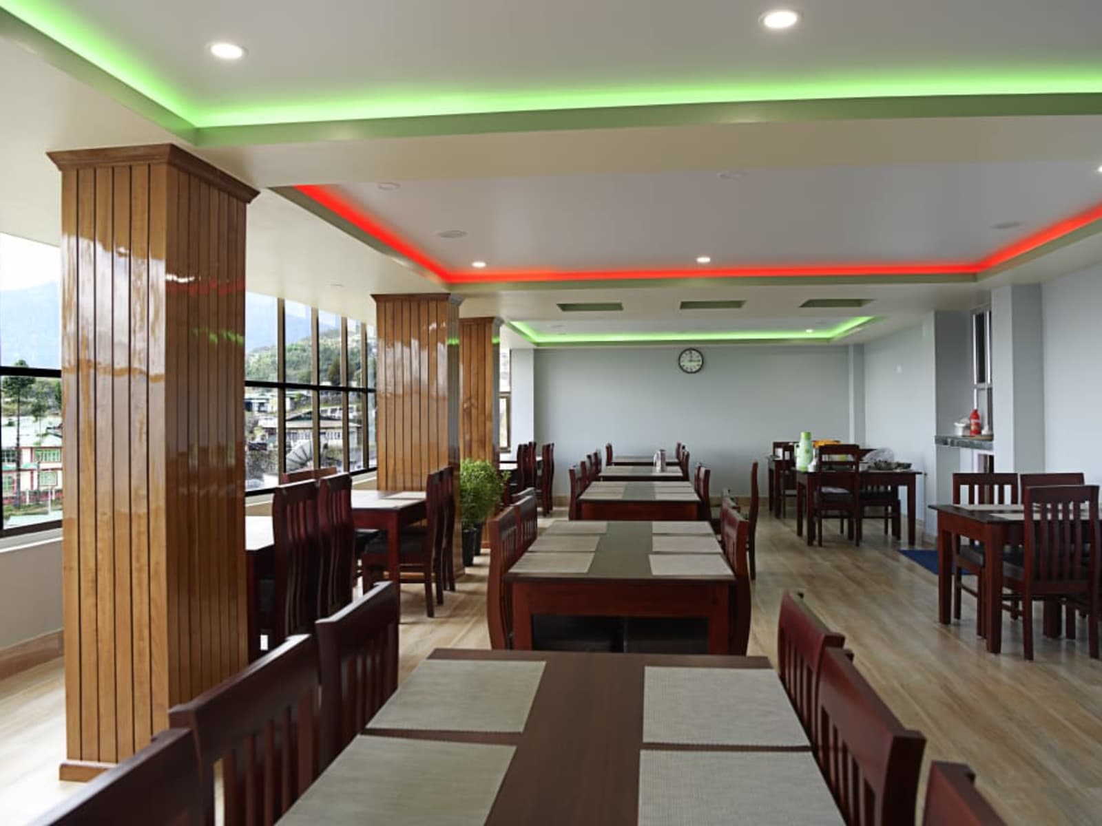 Restaurant interior featuring timber clad pillars and ambient cove ceiling lighting.