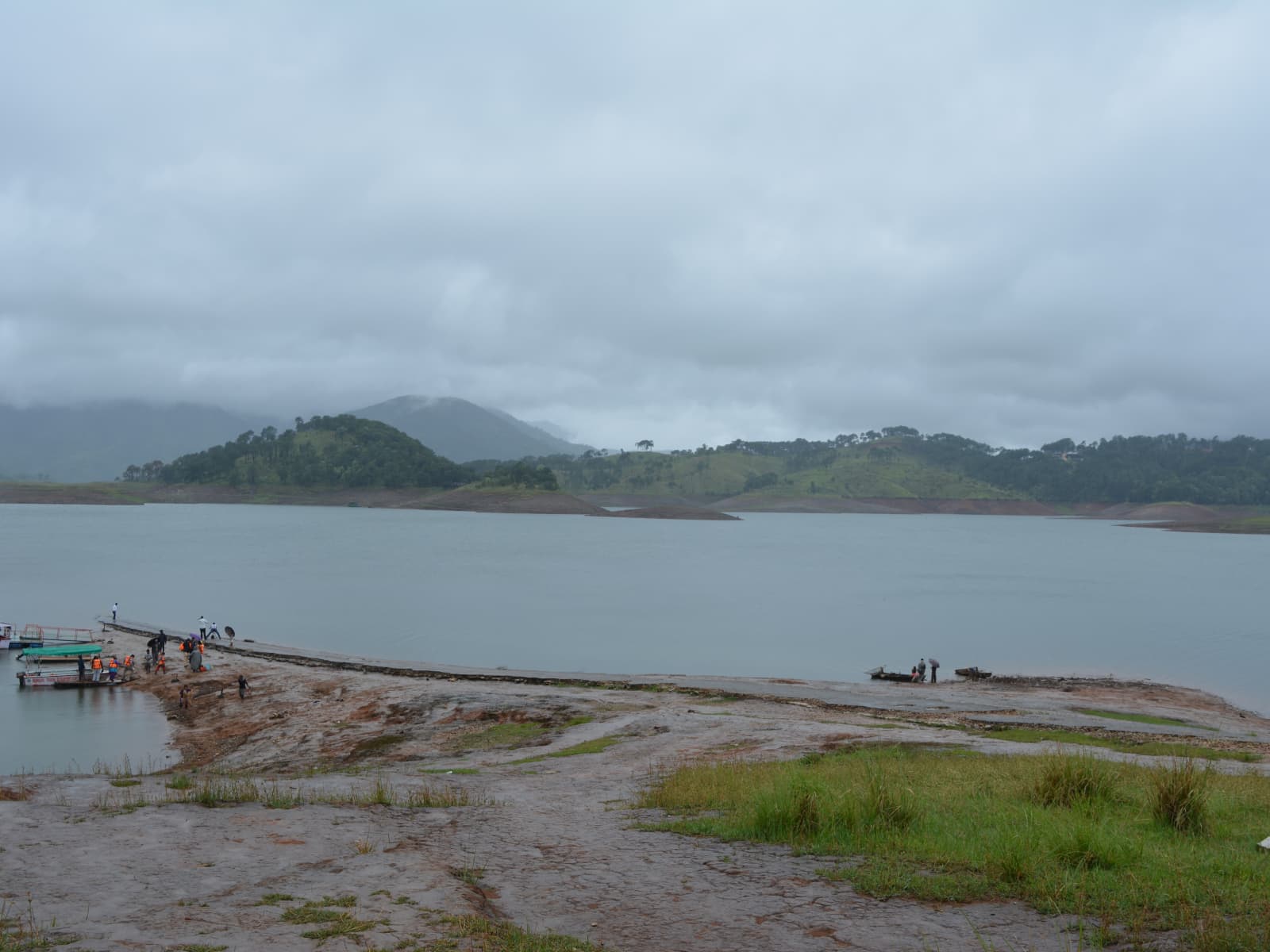 Motorboats and floating wooden jetties anchored along the red soil shoreline of Umiam Lake.