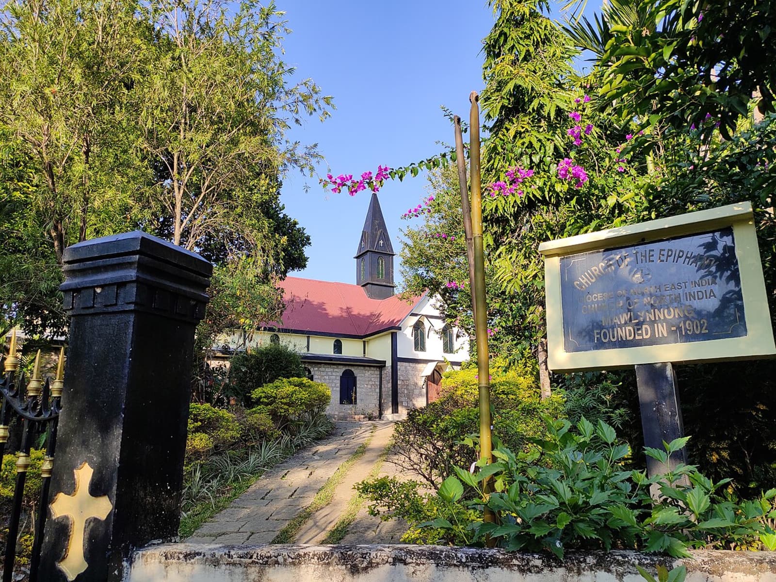 Stone entrance signboard of Church of the Epiphany founded in 1902 with golden cross on black gatepost.
