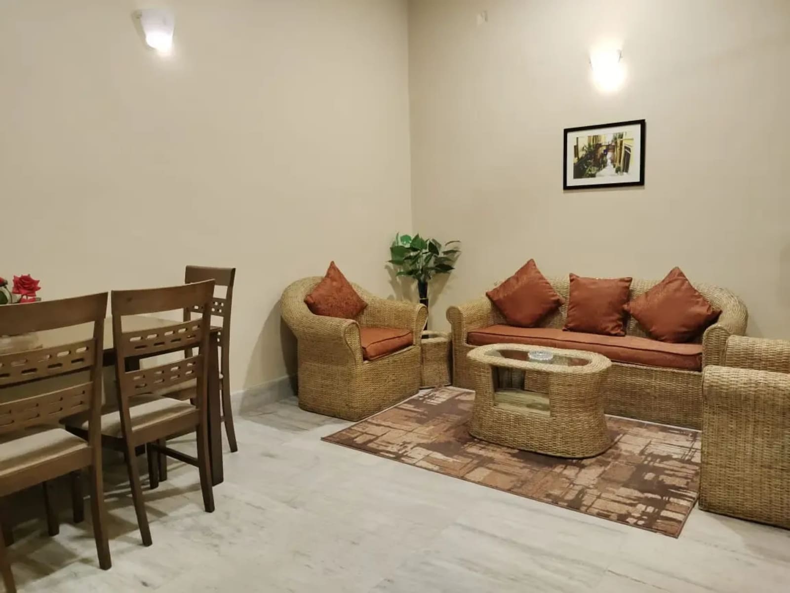 Private living lounge with woven cane sofa set, glass coffee table, floor rug, and dining table in Suite King Room.