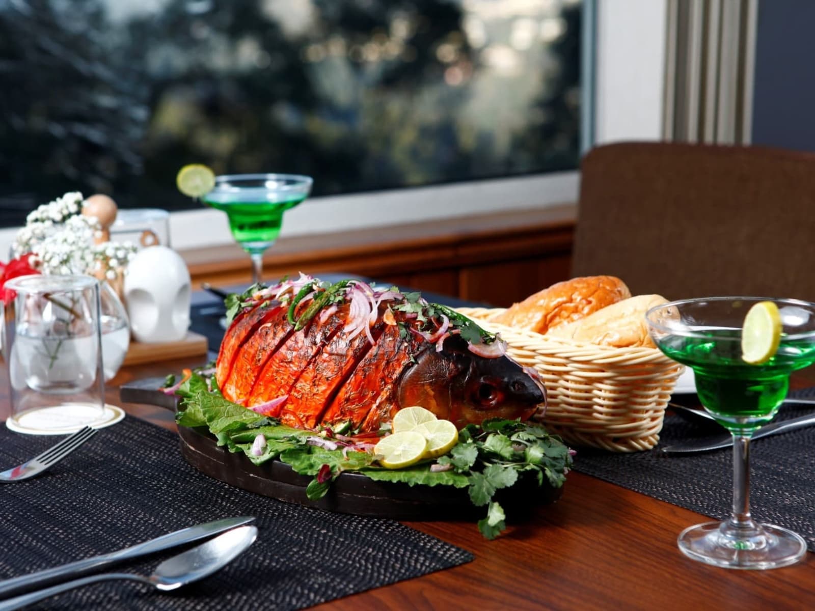 Whole roasted fish sizzler served with fresh bread basket and green mocktail at Morung Cafe.