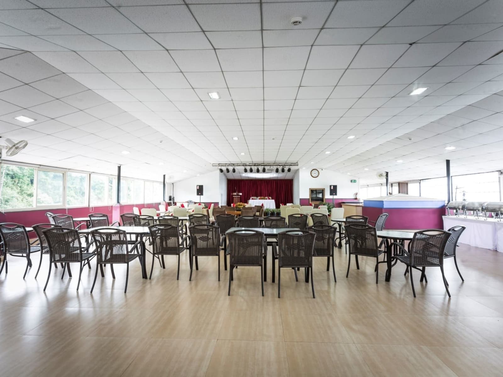 Golden Bamboo dining hall arranged with wicker seating tables and a background buffet serving station.