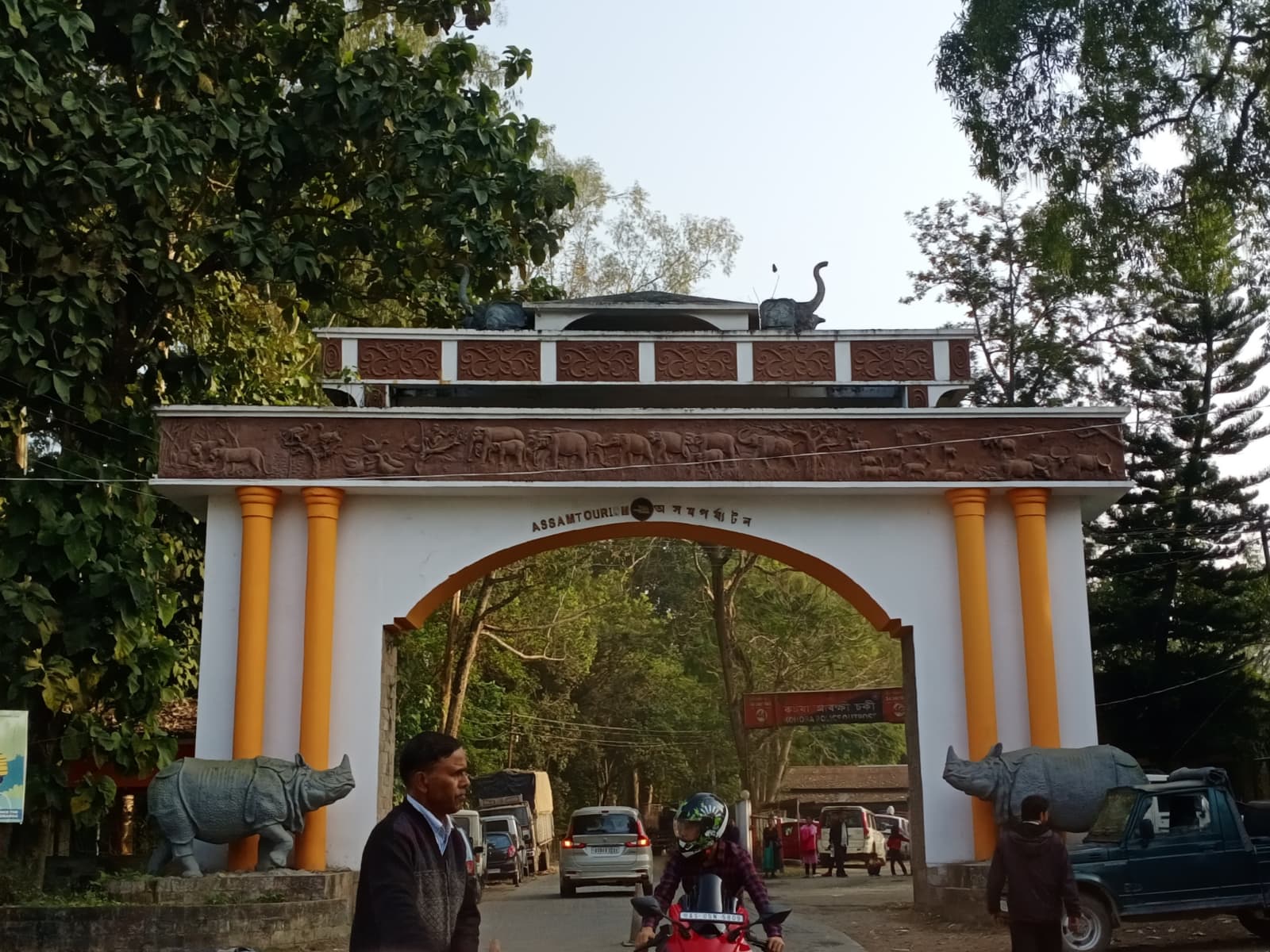 Assam Tourism Kohora welcome portal arch with decorative rhino statues at entrance to Kaziranga National Park.