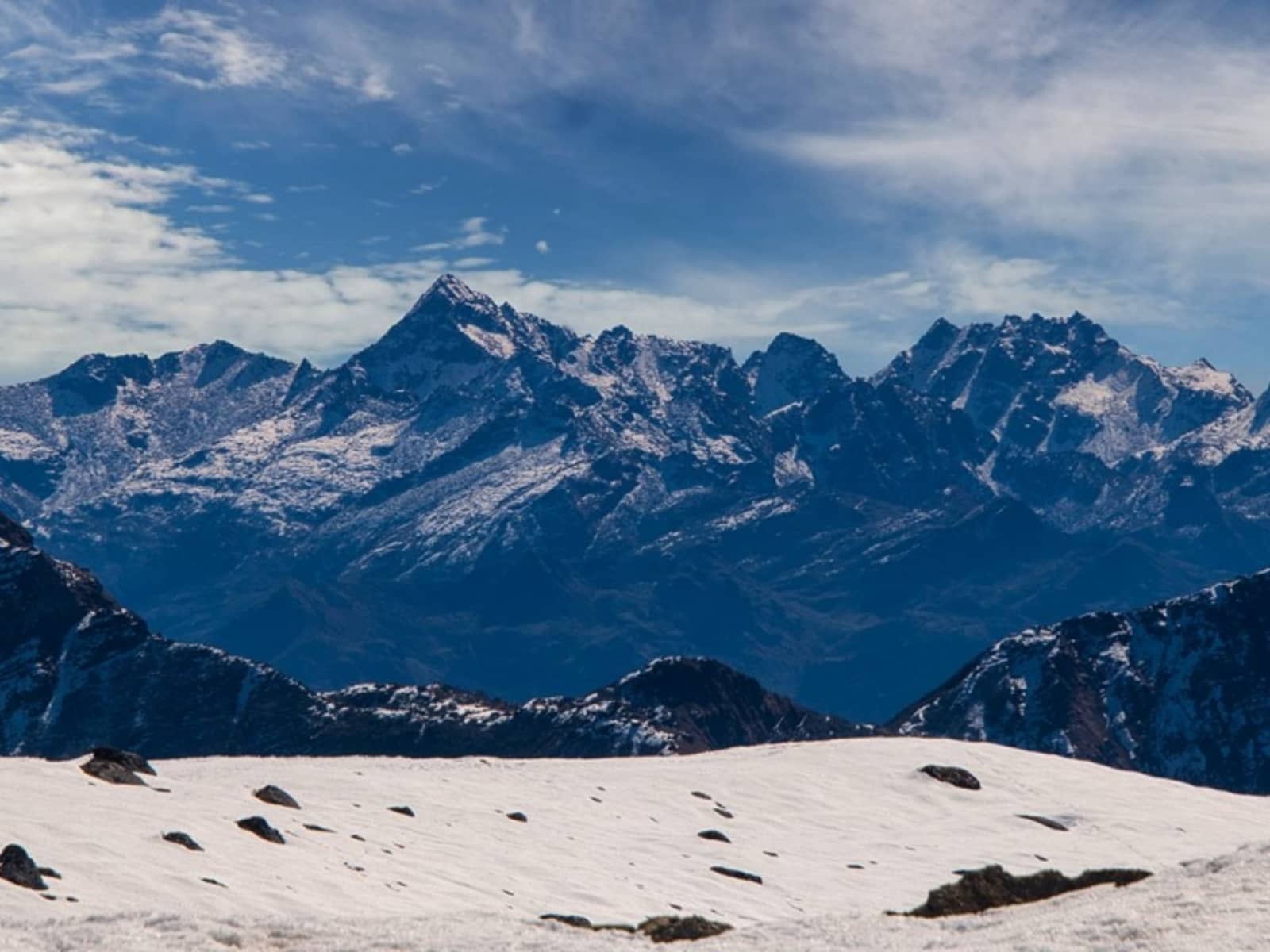 Panoramic view of snow-capped Himalayan peaks and snow slopes at Bum La Pass summit.