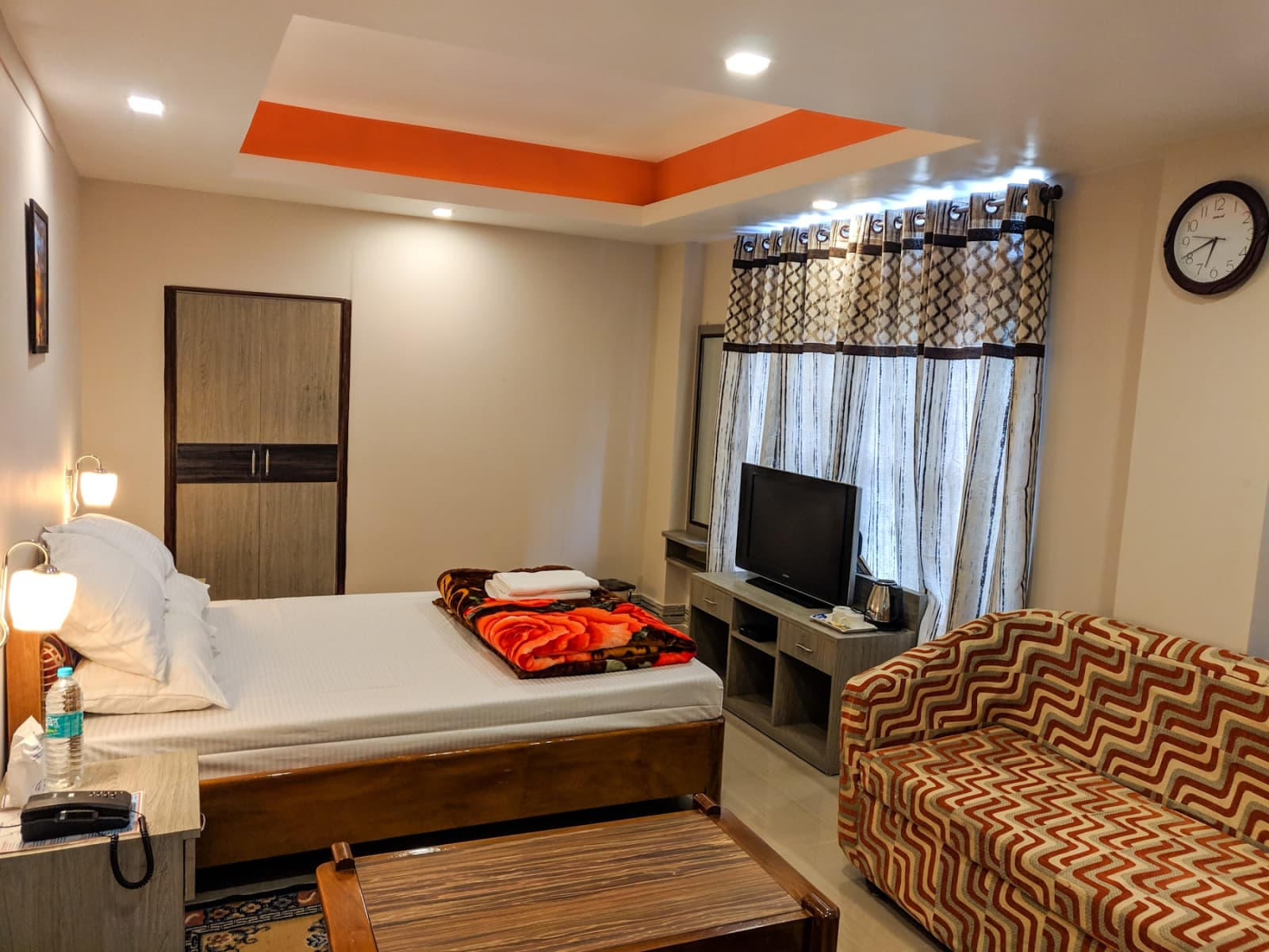 Spacious Super Deluxe quarters appointed with plush king mattress, wardrobe closet, and armchair.