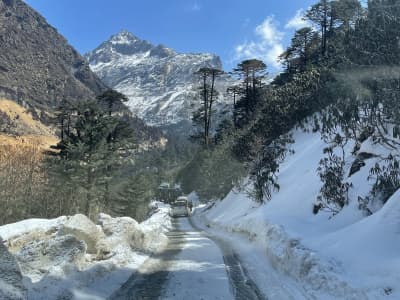 The alpine winding road approaching Sela Pass amidst winter snow drifts.