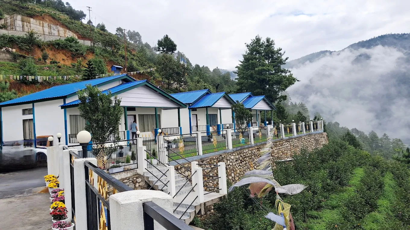 Handcrafted pine cottages nestled among blooming perennial gardens at Wangdi's Resort.