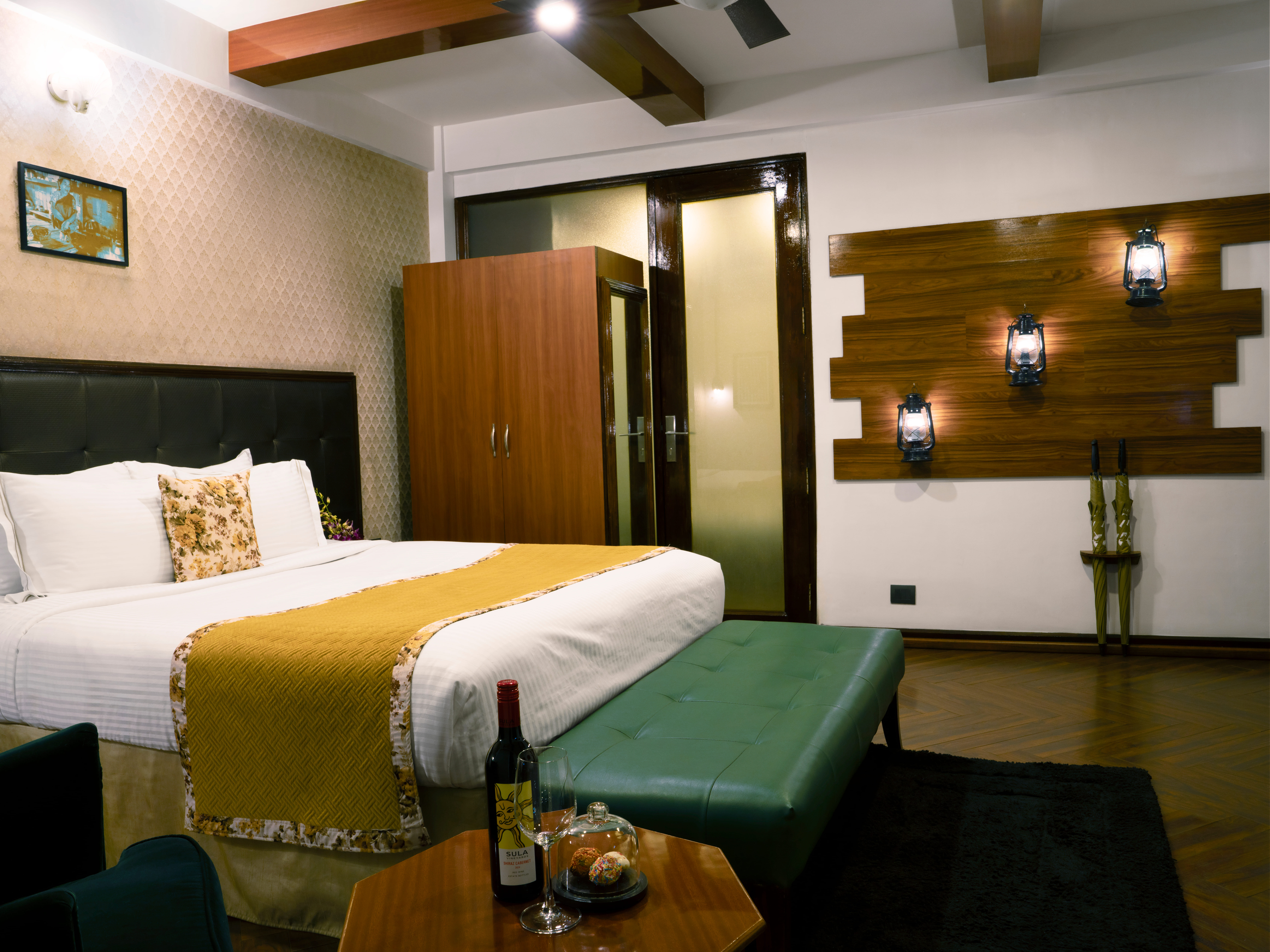 Cozy timber cottage bedroom equipped with king bed, decorative oil lanterns, and complimentary wine setup.