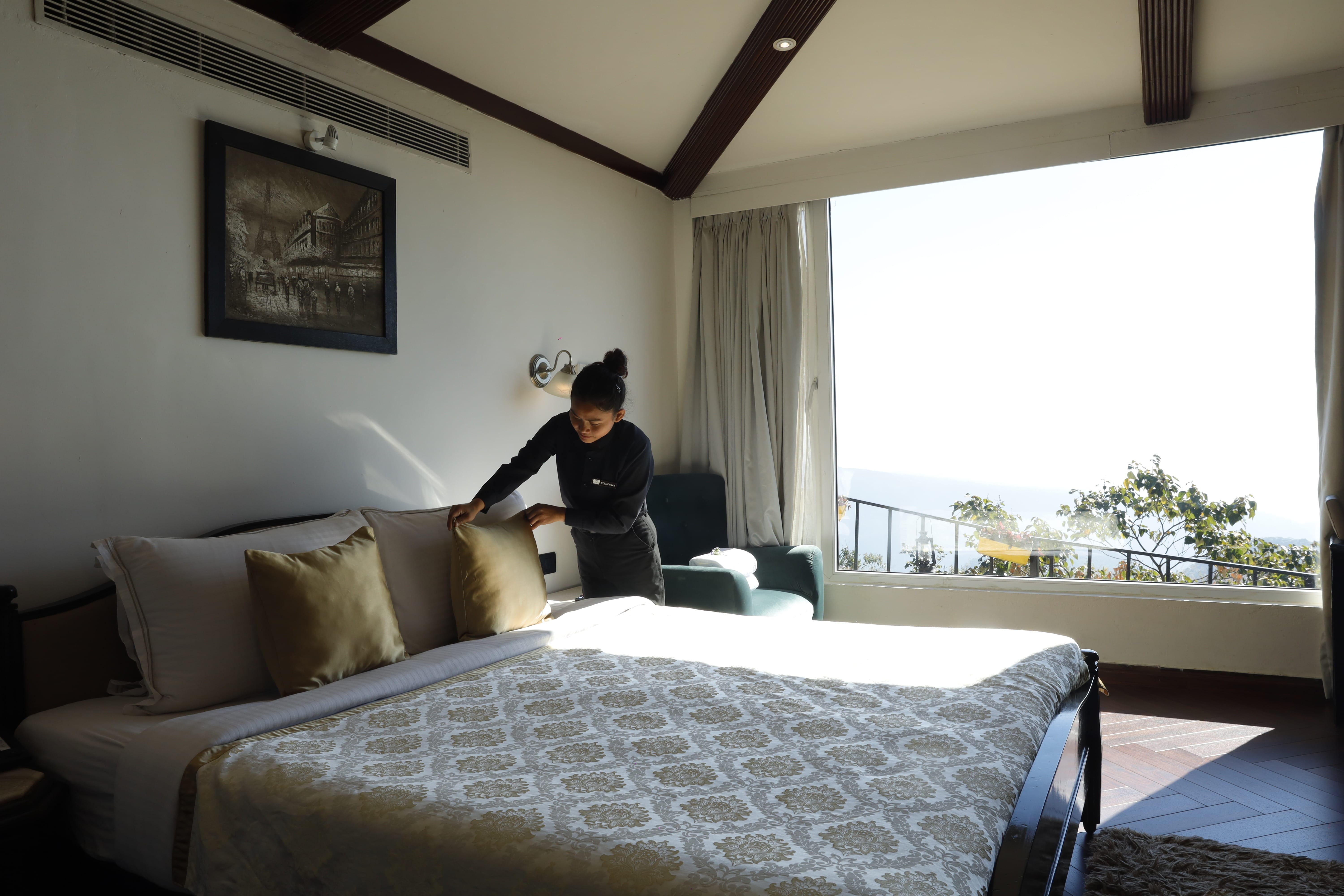 Misty Mountain Villa master bedroom featuring floor-to-ceiling panoramic mountain view glass wall.