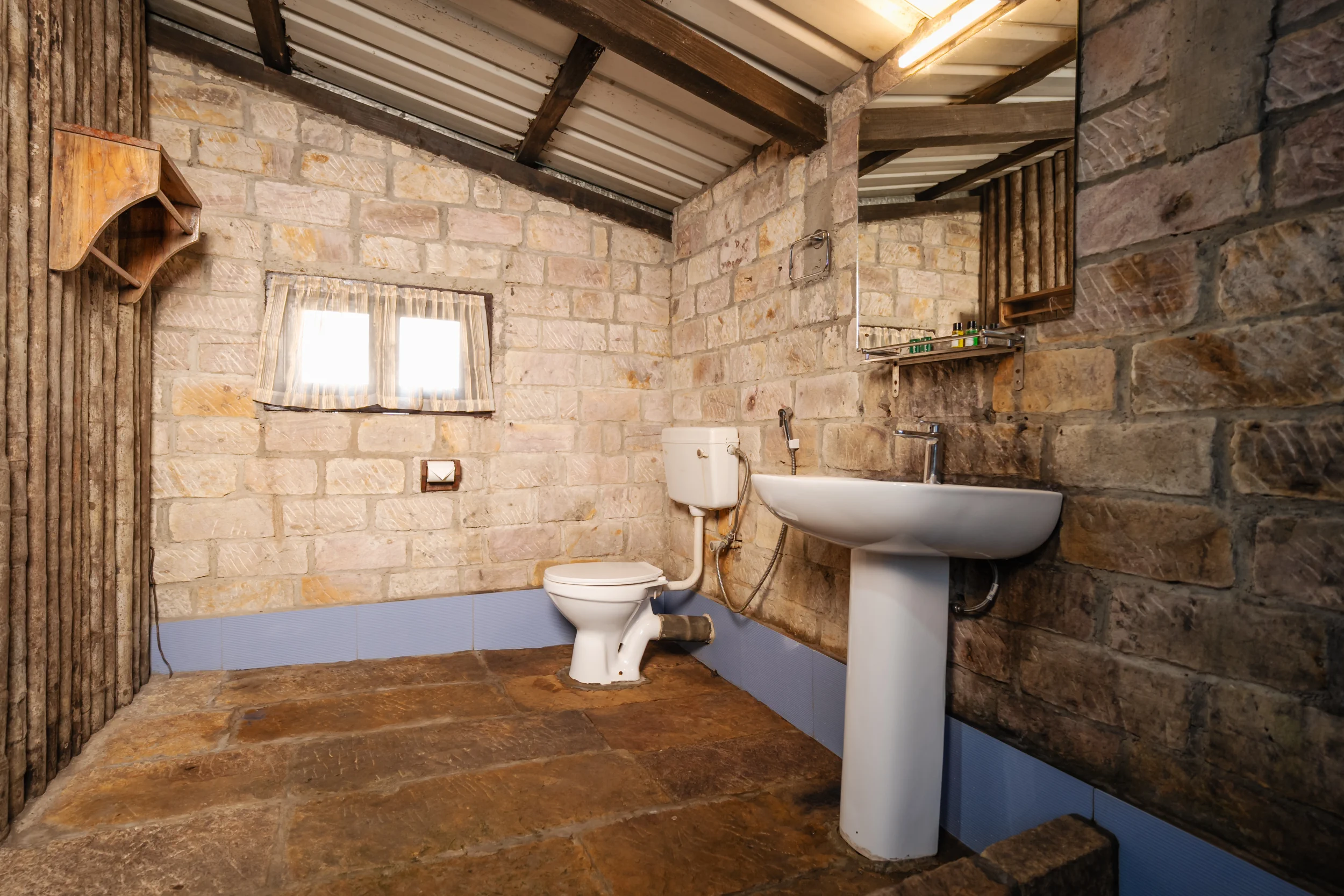 Attached sandstone block bathroom in Pyriam Quad Cottage with pedestal washbasin.