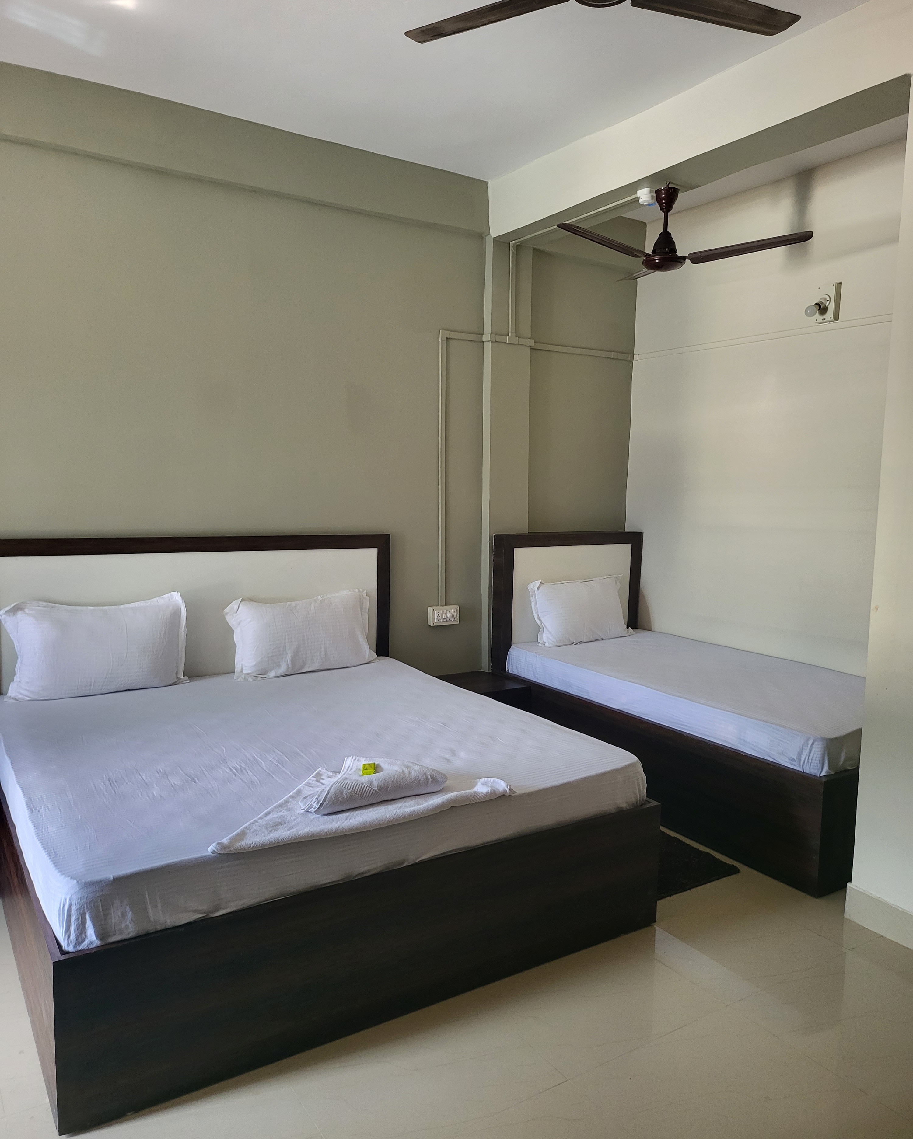 Family triple bedroom configured with one double bed and one single bed for up to three guests.