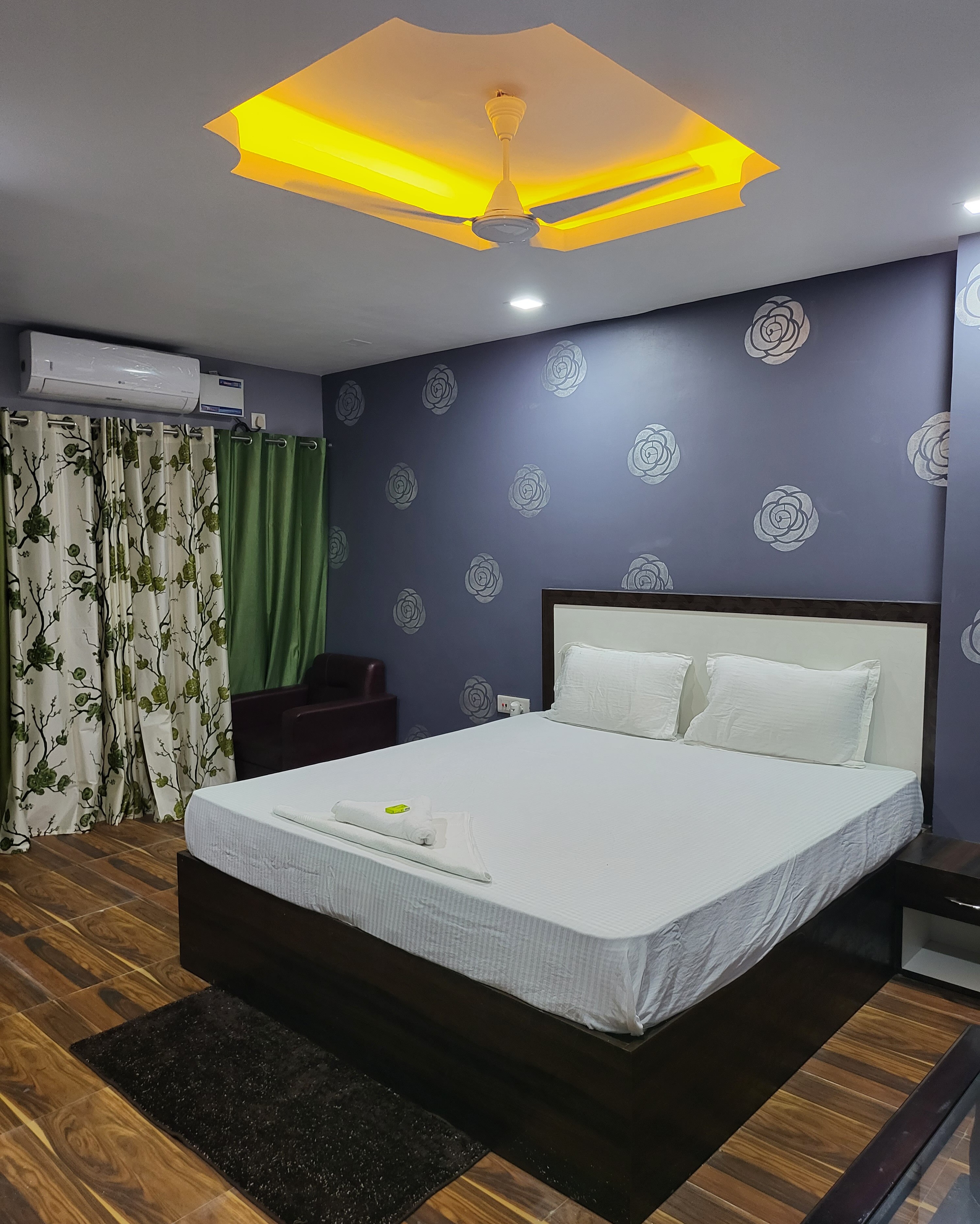 Modern Executive Double room featuring plush king bedding, accent wallpaper, and air conditioning.