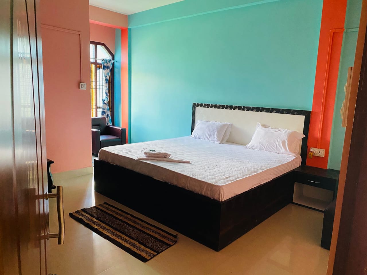 Vibrant Deluxe Double room styled with bold wall colors and comfortable double platform bed.