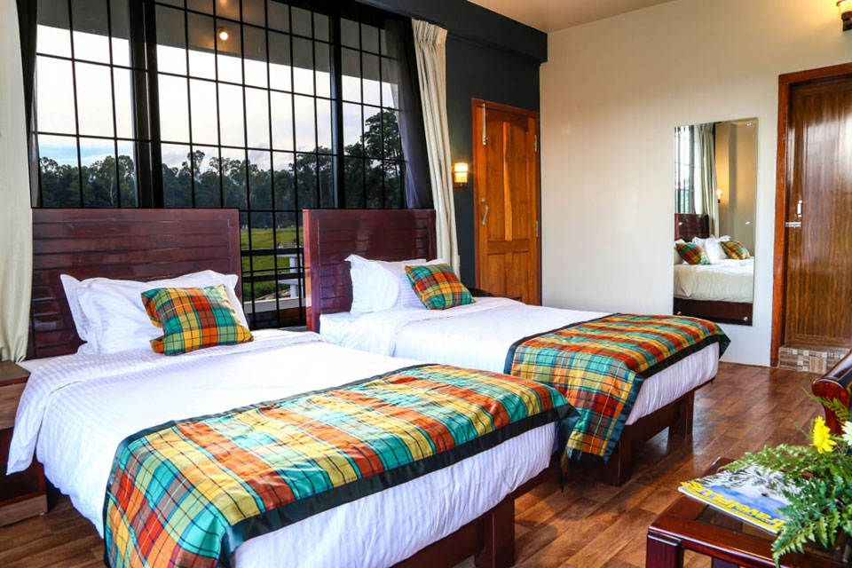 Executive Room features twin beds with dark wooden headboards, tartan accents, and large grid windows.