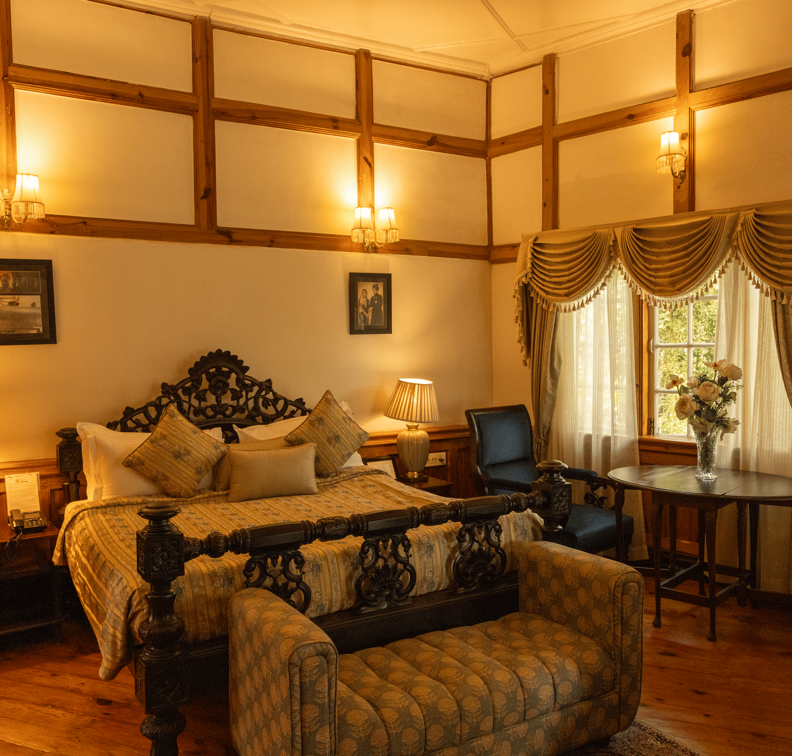Master bedroom in the Maharaja Suite highlighting an intricately hand-carved four-poster king bed and bed bench.