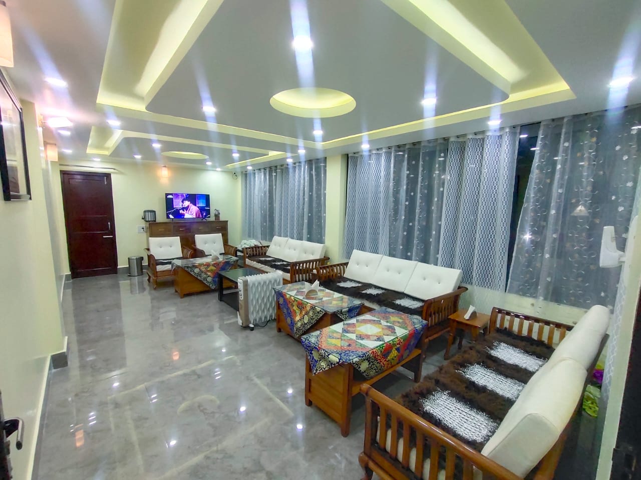 A checkered tiled veranda porch connects the ground floor courtyard to the homestay entrance.