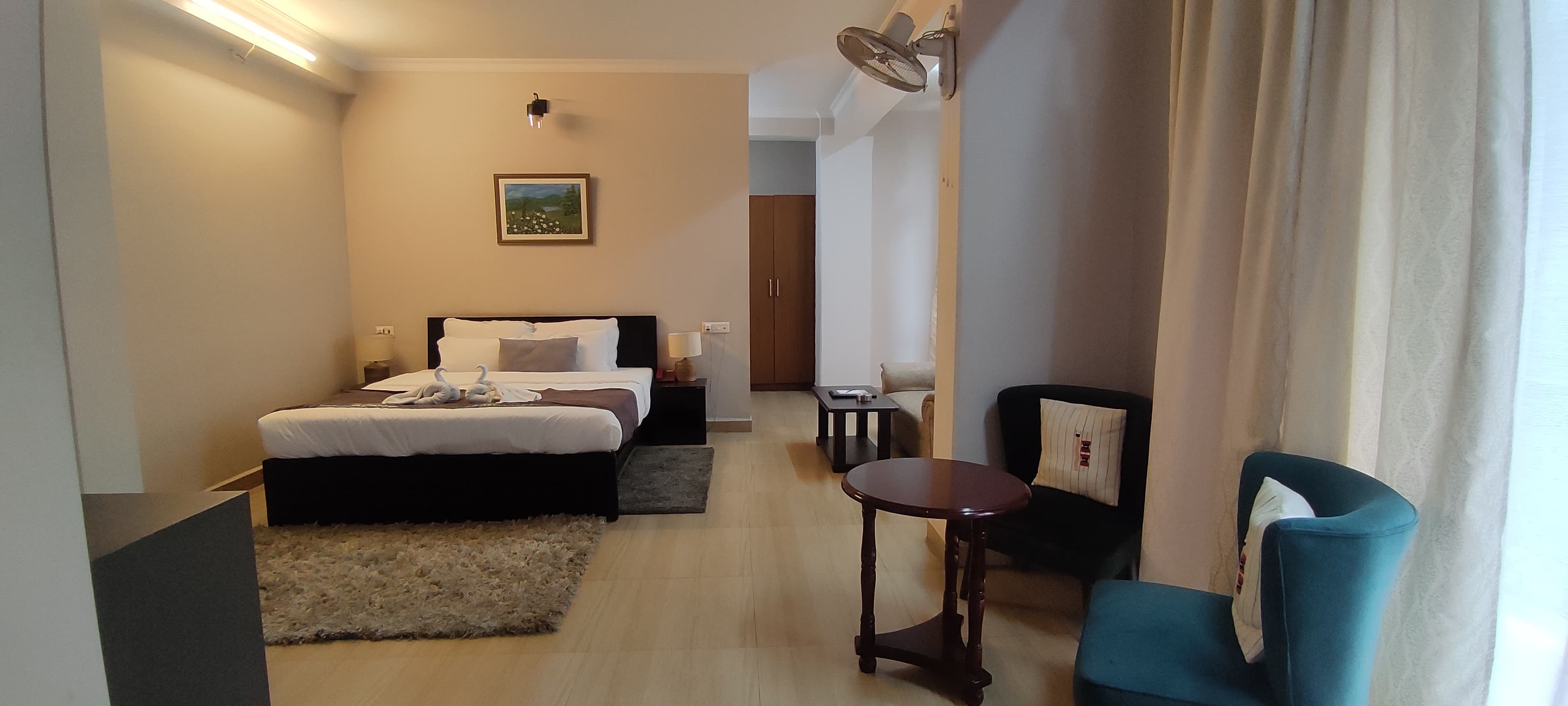 The flagship Junior AC Suite features a open-plan design with a plush king bed and stylish living seating area.