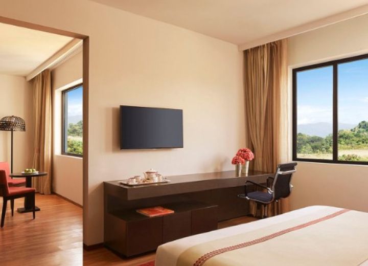 Deluxe Suite layout showing the media workstation desk, wall-mounted TV, and connected living area.