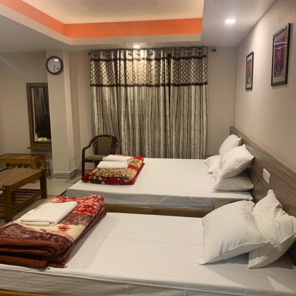 Triple bedroom configured with one double bed and one single bed for small families or travel groups.