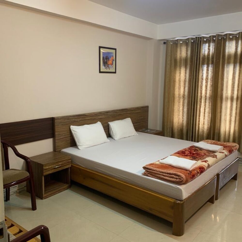 Comfortable Executive Double room with wood-paneled headboard, warm blanket, and reading armchair.