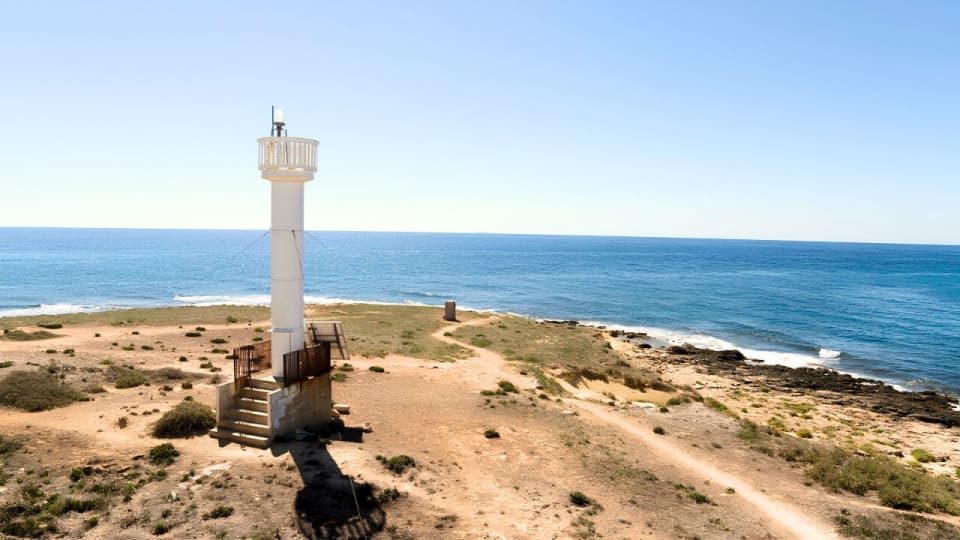 Il faro dell'Isola delle Correnti con la vegetazione della macchia mediterranea