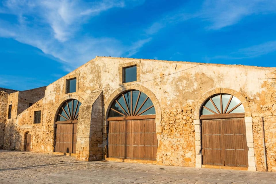 La loggia degli Scieri con le arcate in tufo e il mare, nella tonnara di Marzamemi
