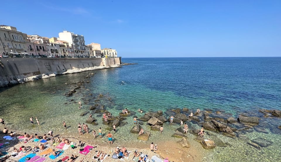 La piccola spiaggia di Cala Rossa vista dall'alto, sul lungomare di Levante a Ortigia