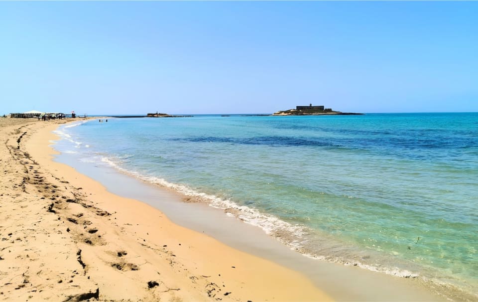 La lunga spiaggia dorata di fronte all'Isola delle Correnti, con il mare e le correnti