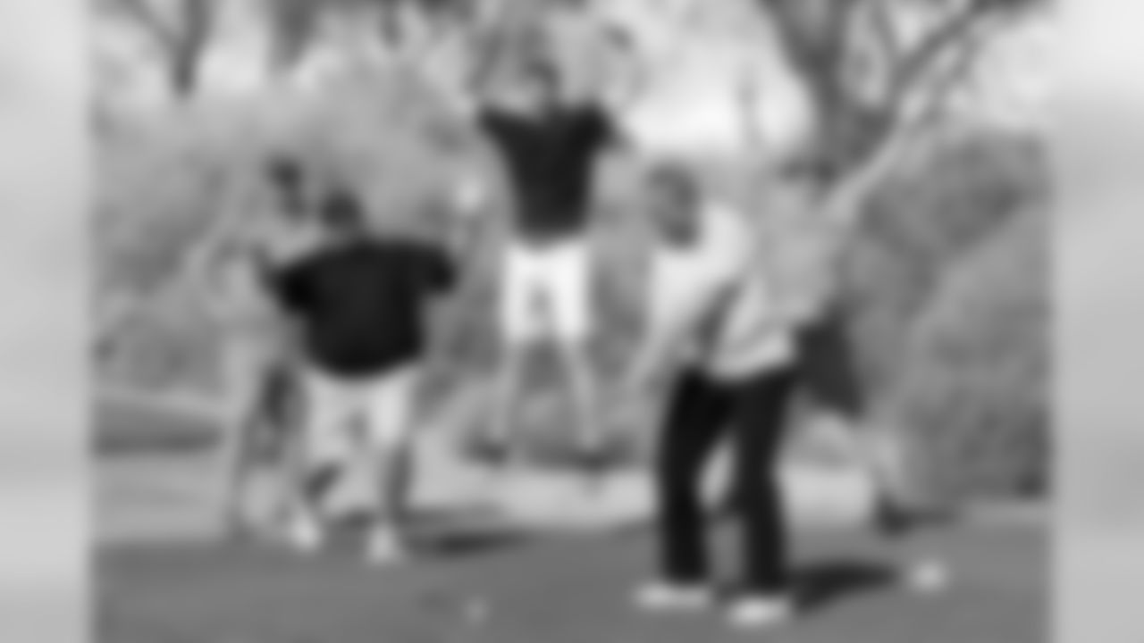 Ann Meyers Drysdale tees off with a jubilant group behind her