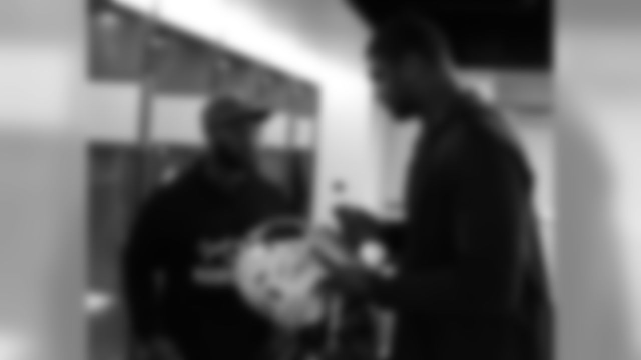 DT Calais Campbell signs a helmet for RB Stepfan Taylor