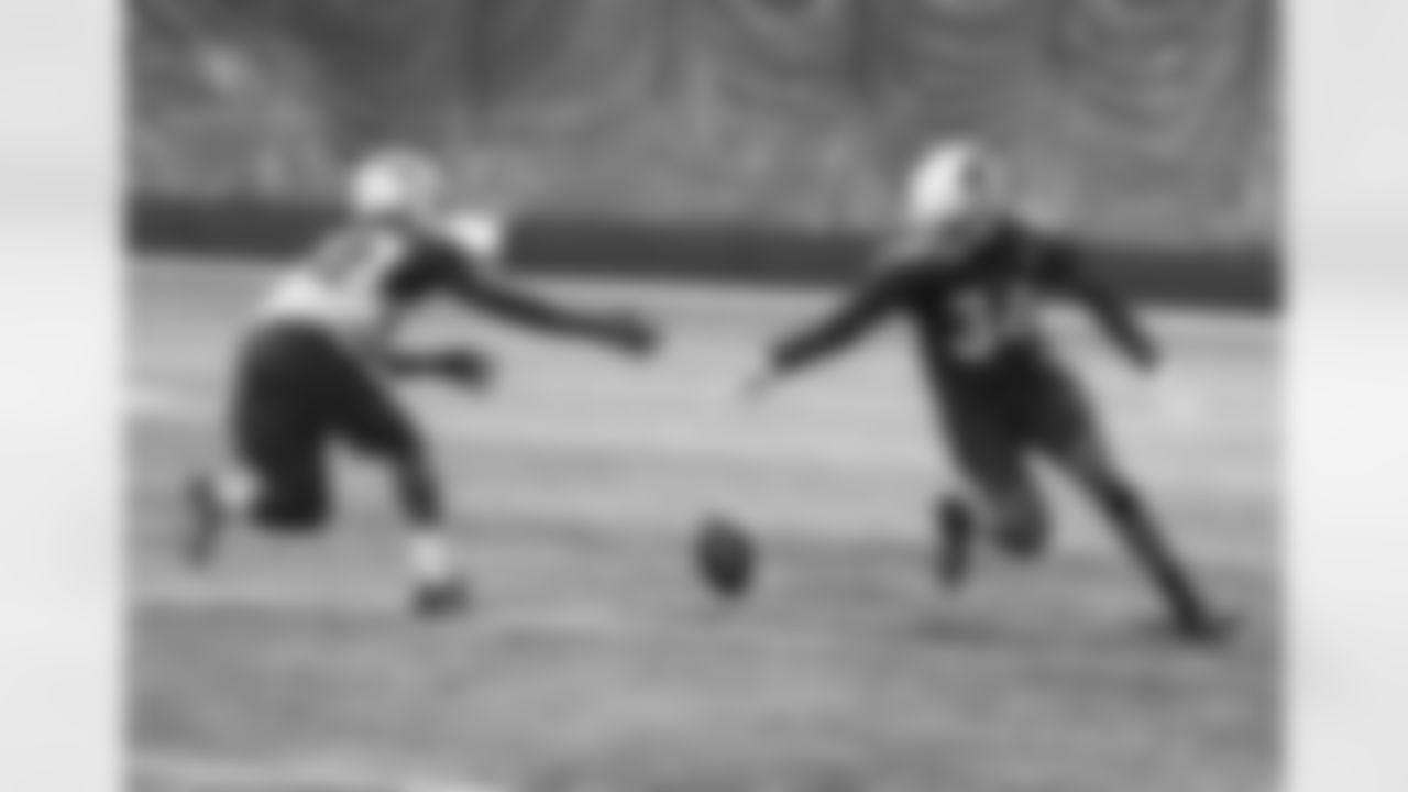 RB T.J. Logan (left) and S Harlan Miller reach for a ball