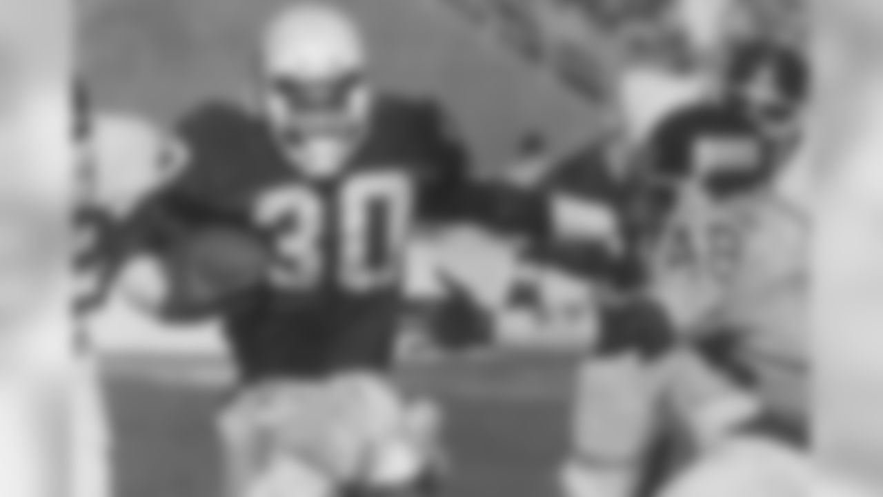 RB Stump Mitchell stiff-arms New York's Kenny Hill in 1988