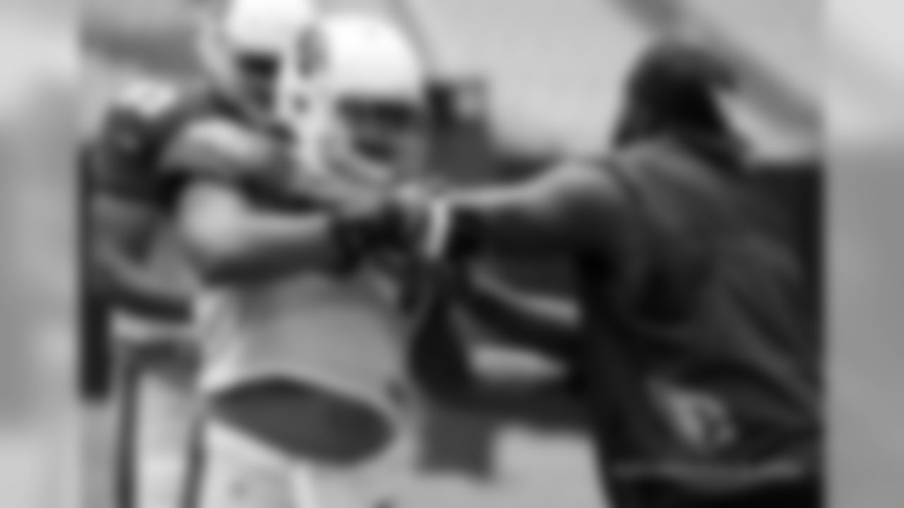 DL coach Brentson Buckner (right) demonstrates technique on NT Xavier Williams