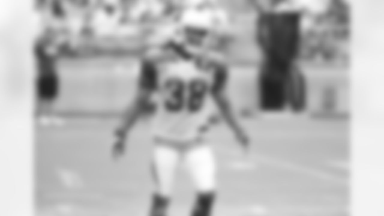 RB Andre Ellington listens to advice after attempting to field a punt
