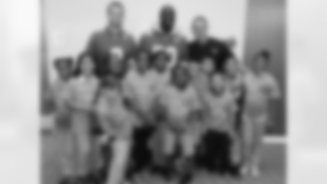 Dustin Colquitt and Justin Houston pose with children who received free dental care from Team Smile.