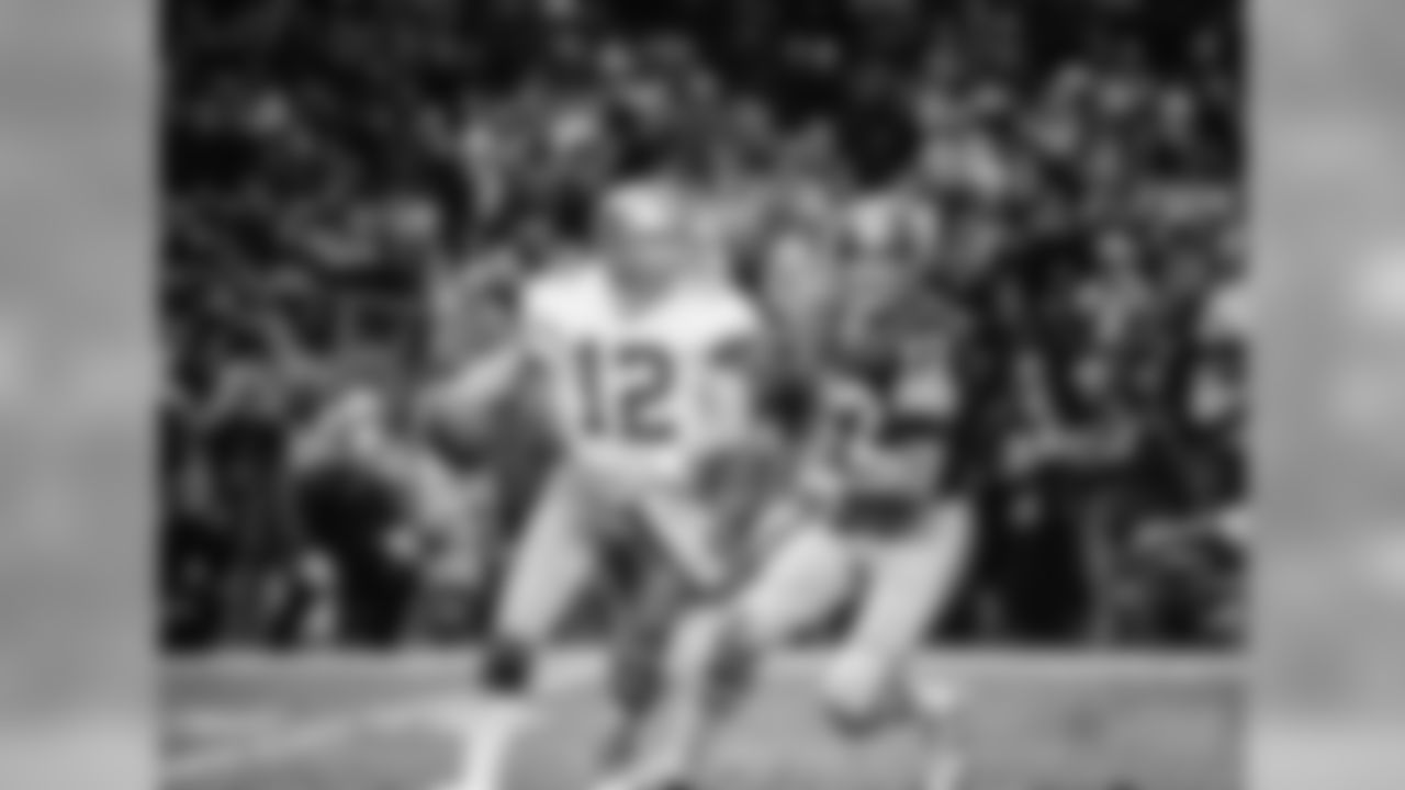 Dallas Cowboy quarterback Roger Staubach steps out of the pocket and runs with the ball during first period action with the Washington Redskins at Robert F. Kennedy stadium in the nation's Capital Nov 27, 1977. Redskin defensive tackle Diron Talbert chases Staubach. (AP Photo/Charles Tasnadi)