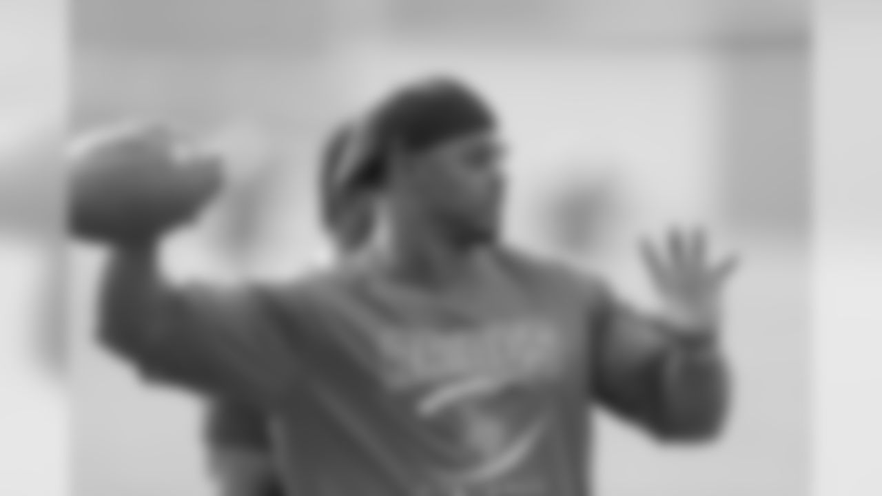 Brian Dawkins throws a football to a Raines player during practice