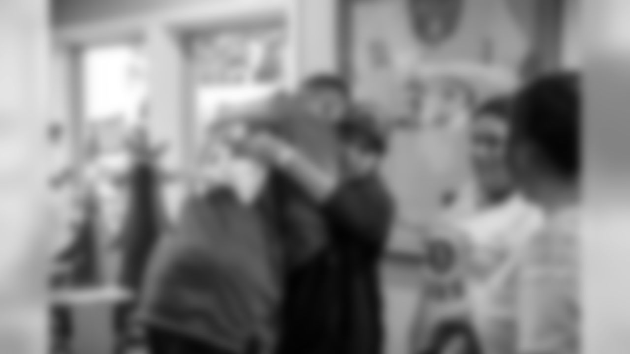 DE Derek Barnett hugging one of the children.