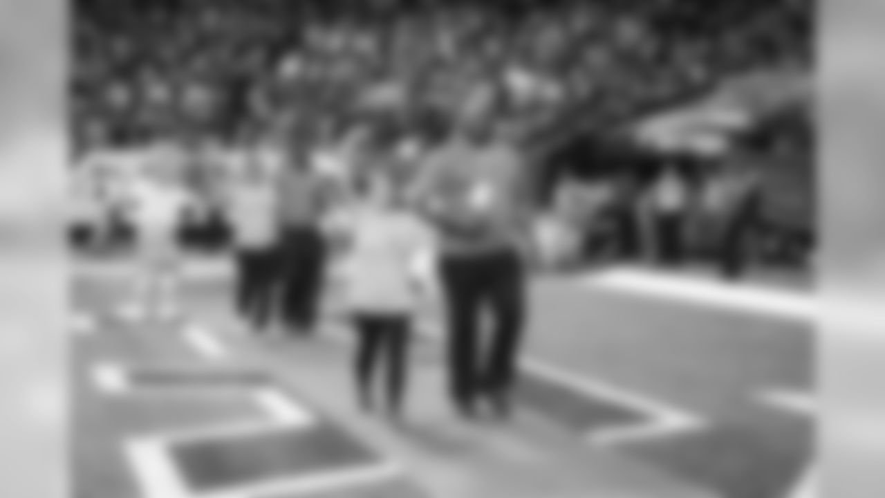 Breast cancer survivors received pink roses and were escorted out of the tunnel onto the field by Falcons alumni